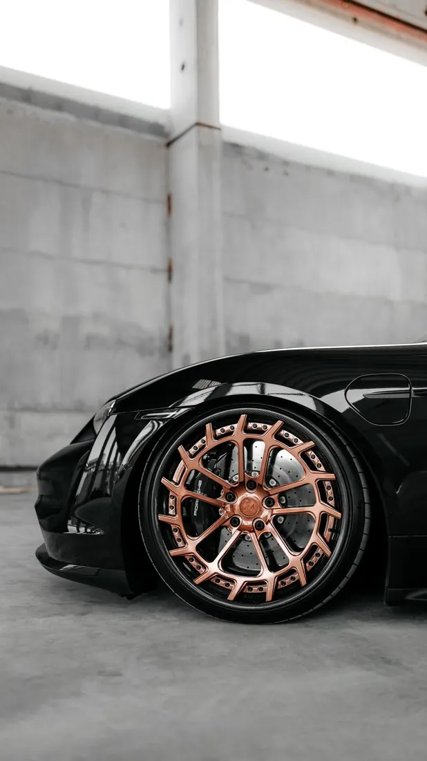 Detailing llantas: rin color cobre en un auto negro brillante