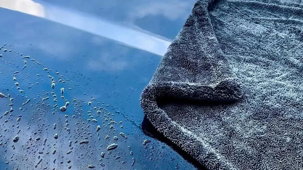 Toalla de microfibra sobre un cofre negro con gotas de agua